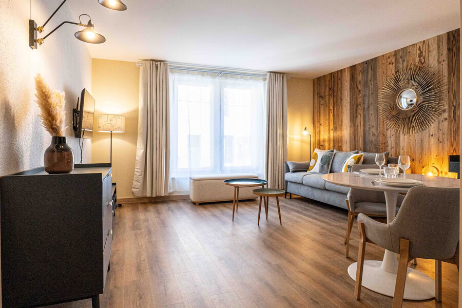 airbnb_relookea_3B Une chambre avec un lit double, un paravent tressé en tête de lit et de la décoration en bois après un home staging