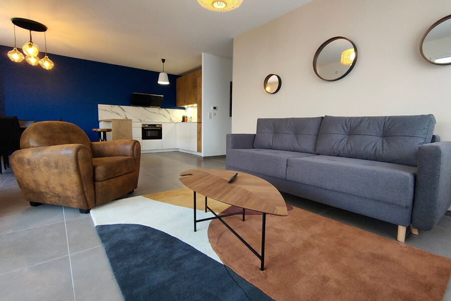 airbnb_relookea_3B Une chambre avec un lit double, un paravent tressé en tête de lit et de la décoration en bois après un home staging