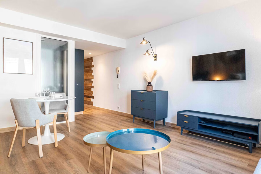 airbnb_relookea_3B Une chambre avec un lit double, un paravent tressé en tête de lit et de la décoration en bois après un home staging