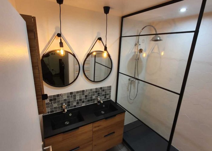 renovation-salle-bain-apres Une salle de bain avec meuble en bois double vasques et une douche moderne après rénovation