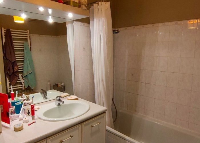 renovation-salle-bain-avant Une salle de bain avec un meuble simple vasque et une baignoire avant rénovation